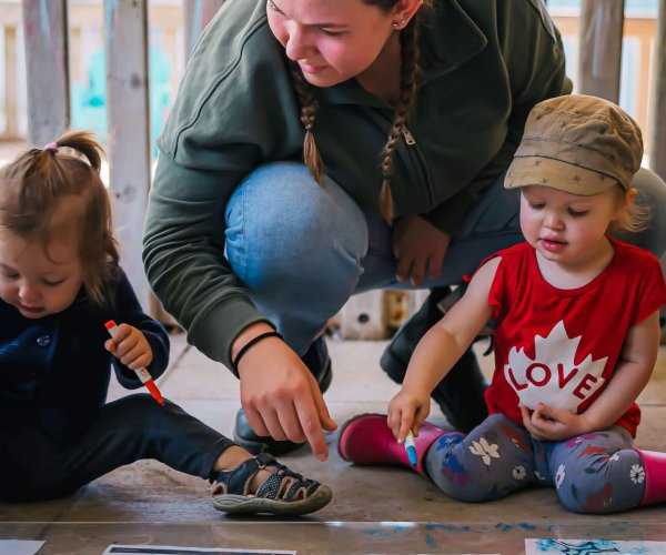 alt='educator playing with students outside'